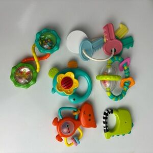 Large bundle of baby toys like rattles, book, loveys